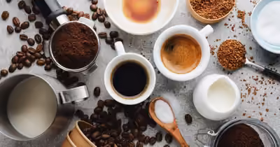 Espresso fraîchement extrait entouré de grains de café et de lait