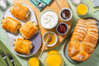 Pains au chocolat, yaourt, confiture, miel et jus d'orange pressé